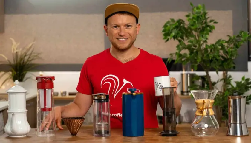 Mann mit verschiedenen Kaffeebereitern, die zeigen, welche Kaffeezubereitung die beste ist.