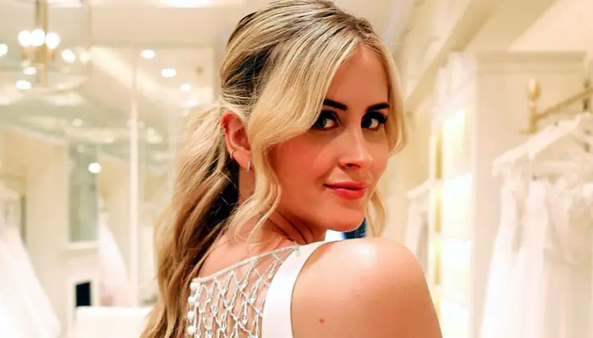 Valentina Ferragni sonríe con un vestido blanco de tirantes y detalles de perlas, en una tienda de novias.