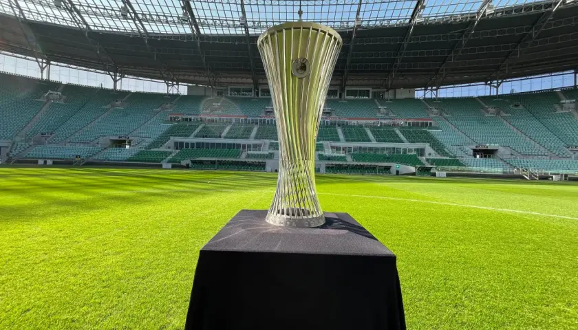 Błyszczący puchar Konfederacji UEFA na tle pustego stadionu.