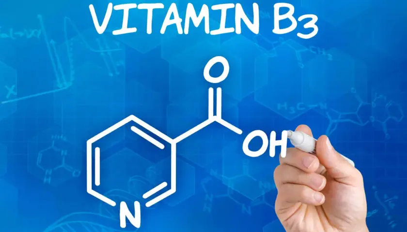 Die chemische Struktur von Vitamin B3, auch bekannt als Niacinamid, wird auf blauem Hintergrund mit Formeln und Graphen gezeichnet.
