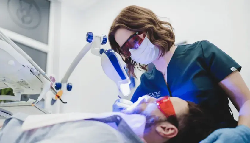 Dentystka wykonuje higienizację zębów w ciąży, dbając o zdrowy uśmiech przyszłej mamy.