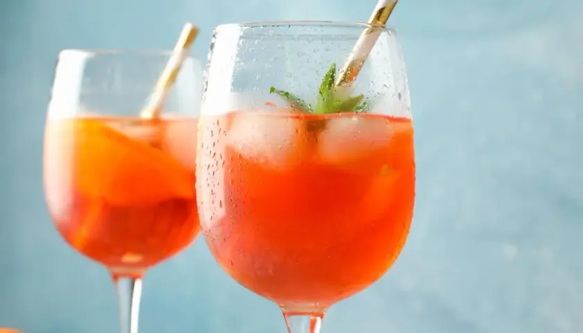 Zwei erfrischende Aperol Spritz mit Eis und Minze, bereit für einen sonnigen Nachmittag.