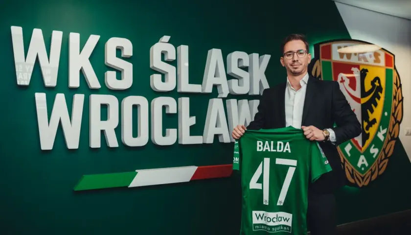 Dyrektor sportowy WKS Śląsk Wrocław, Balda, prezentuje zieloną koszulkę z numerem 47.
