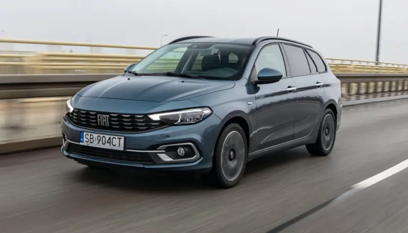 Niebieski Fiat Tipo kombi jedzie po moście. Prawidłowe ciśnienie w oponach zapewnia bezpieczeństwo.