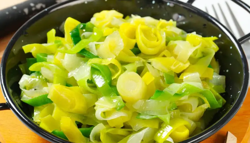 Porri in padella, teneri e dorati, pronti per essere gustati.