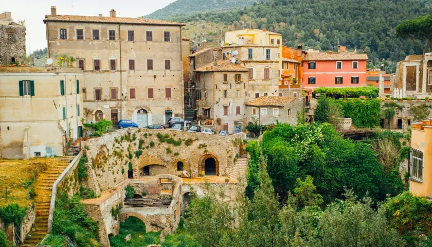 Vue d'ensemble de la Villa Gregoriana, avec ses bâtiments anciens, ses ruines et sa végétation luxuriante.