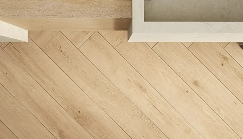 Dettaglio di un pavimento in legno con posa a spina di pesce, che mostra eleganti schemi posa piastrelle.