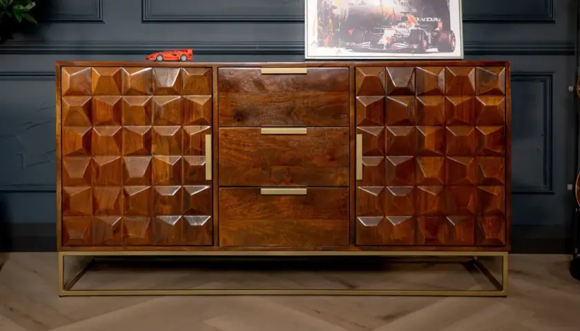 A geometric carved mango wood finish sideboard with brass handles and a gold metal base.