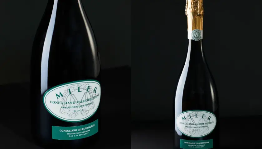 Dwie butelki prosecco. Jedna z nich ma złoty kapturek. Etykiety informują o pochodzeniu i zawartości procentowej alkoholu.