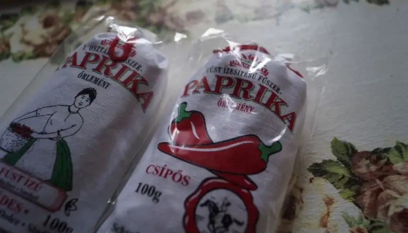 Dwie paczki mielonej papryki z Węgier, jedna z rysunkiem kobiety z koszykiem, druga z papryczką.