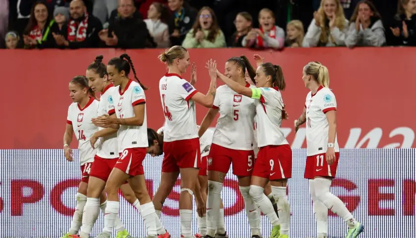 Piłkarki w biało-czerwonych strojach świętują sukces. To dumne polskie dania na boisku, pełne radości i sportowego ducha.