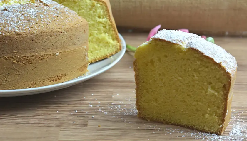 Un ciambellone soffice e alto, spolverato di zucchero a velo, pronto per essere gustato. La ricetta perfetta per una colazione golosa.