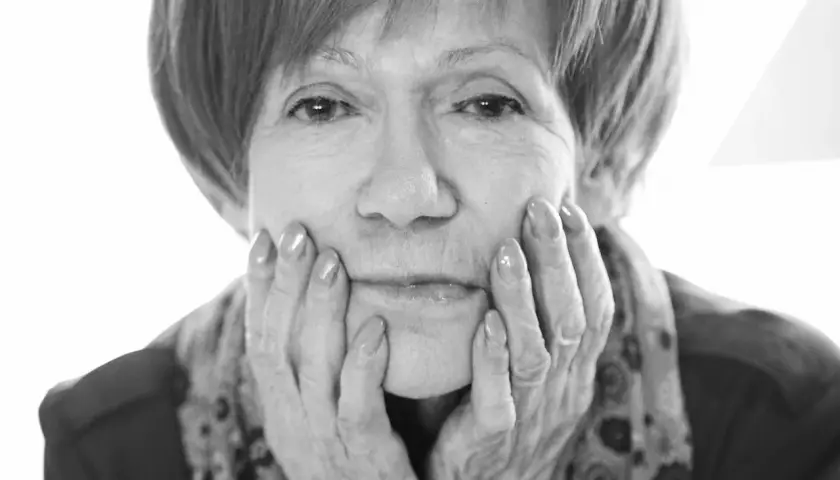 Portret Marii Czubaszek, z dłońmi podpartymi na policzkach. Jej spojrzenie przywodzi na myśl jej słynne maria czubaszek cytaty.