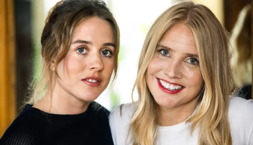 Två kvinnor, en med brunt hår uppsatt, den andra med blont hår, ler mot kameran. Amanda Romare är en av dem.