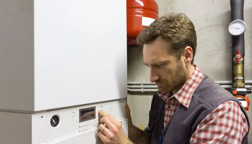 Tecnico che regola una caldaia. Guida alla scelta della caldaia ideale per la tua casa.