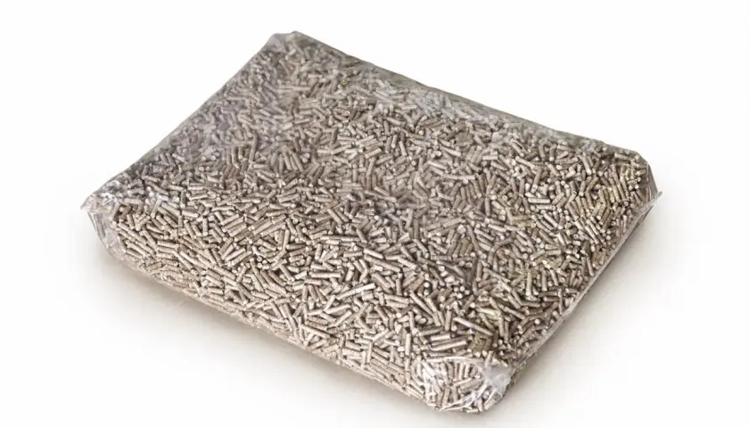 Przezroczysta folia wypełniona drobnym, jasnobrązowym pelletem. To ekologiczne paliwo, pellet stalowa wola, gotowe do ogrzania domu.