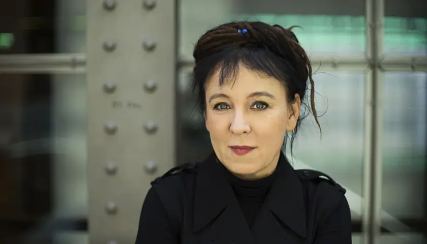 Olga Tokarczuk, laureatka Nagrody Nobla, w czarnym płaszczu. Jej życiorys to fascynująca podróż przez świat literatury.