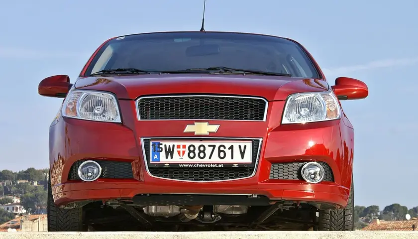 Czerwony samochód Chevrolet z austriacką tablicą rejestracyjną 15-W 88761 V.