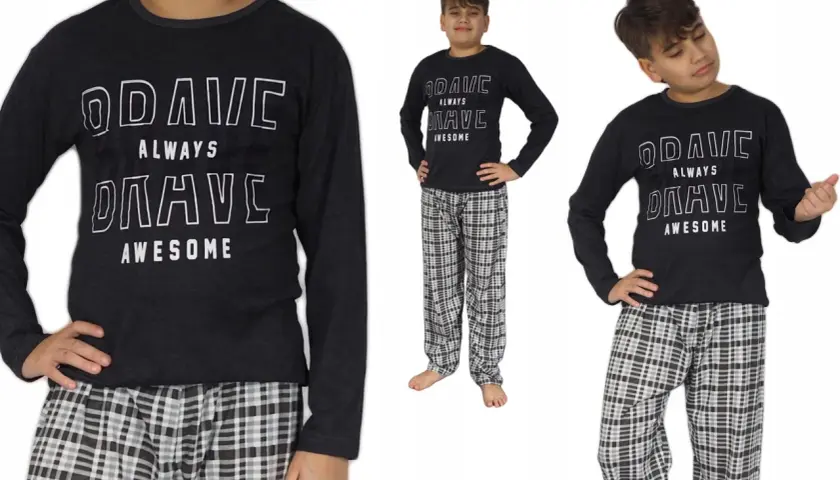 Chłopiec w piżamie z napisem "BRAVE ALWAYS AWESOME" i w kratę.