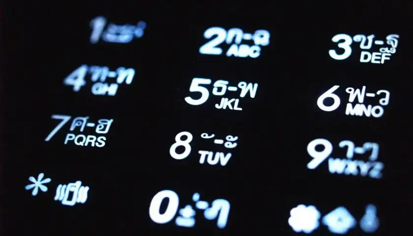 Klawiatura telefonu z cyframi i znakami w języku tajskim. 791 jaka to sieć?