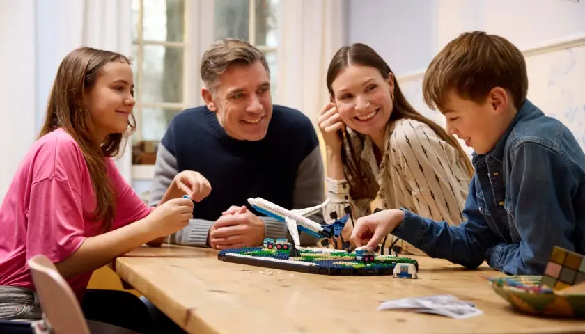 Familie baut gemeinsam ein Flugzeugmodell. Die Faszination LEGO verbindet Jung und Alt.