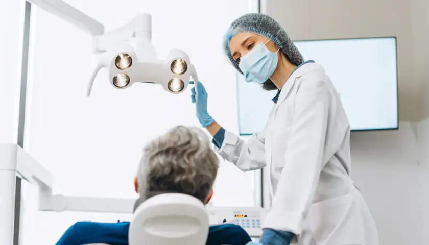 Dentystka w masce i rękawiczkach przygotowuje się do zabiegu. Pacjent siedzi na fotelu. Czy dentysta może wystawić L4?