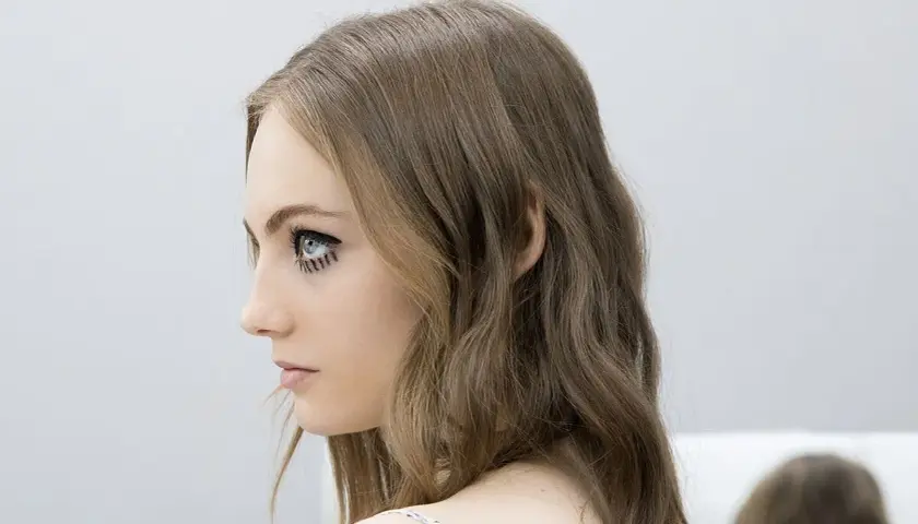 Chica con media melena escalada y maquillaje dramático en los ojos.