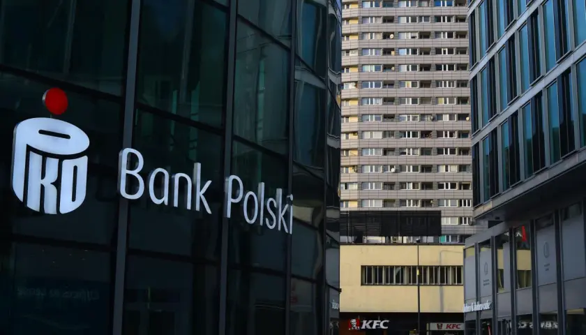 Logo PKO Bank Polski na szklanej fasadzie. W tle blok mieszkalny i KFC. PKO BP rekomendacje.