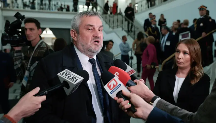 Mężczyzna z siwą brodą, przypominający ojca Agnieszki Pomaskiej, udziela wywiadu dziennikarzom.