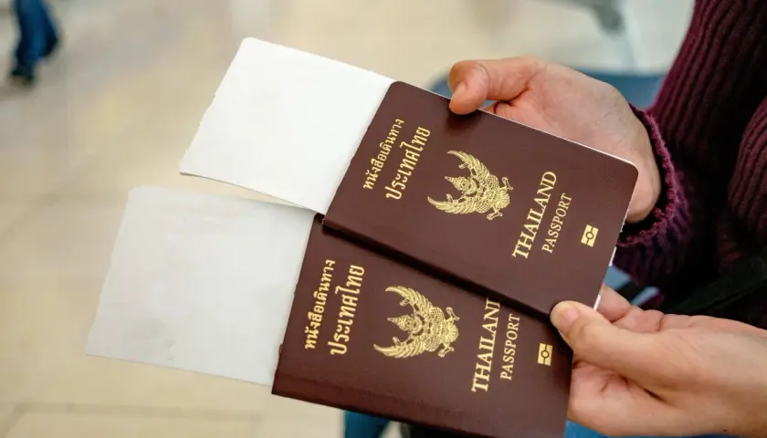 Zwei Reisepässe von Thailand werden gehalten, bereit für die Einreise. Ein 10-Jahres-Visum Thailand ist vielleicht schon beantragt.