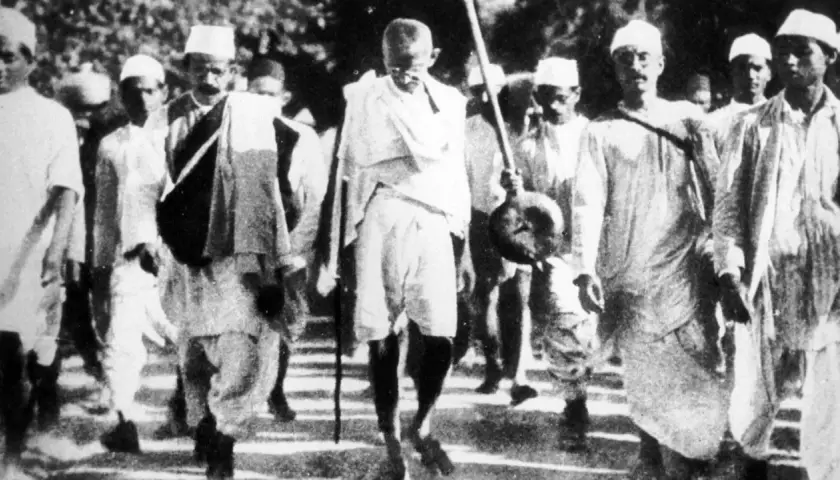Mahatma Gandhi führt eine Gruppe von Menschen an, die sich auf einen Marsch vorbereiten.