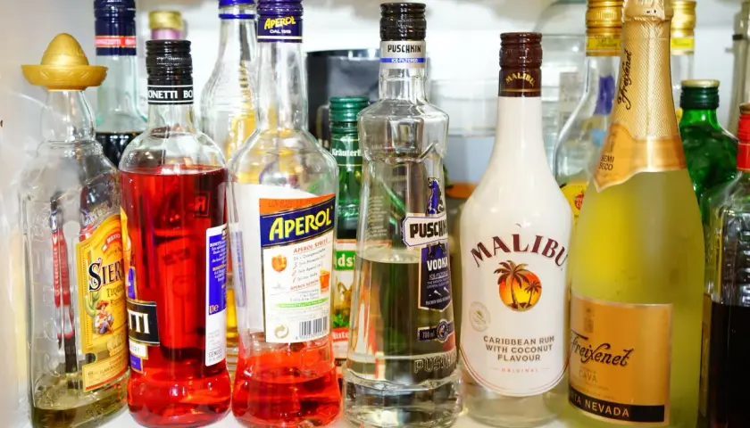 Na półce stoją butelki z alkoholami: Aperol, Malibu, Puschkin, Freixenet Cava i inne. Czy Schweppes ma alkohol? Nie ma go na zdjęciu.
