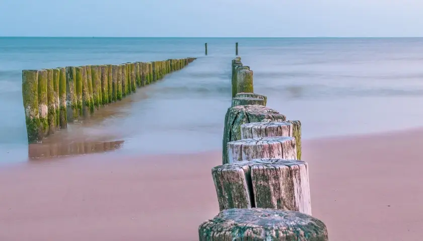 Drewniane pale na plaży, prowadzące do morza. Może tu jest najcieplejsza woda w Bałtyku?