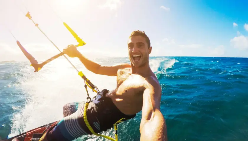Szczęśliwy facet na kitesurfingu robi selfie. Wskazówka, jak zrobić dobre selfie facet: uśmiech i akcja!