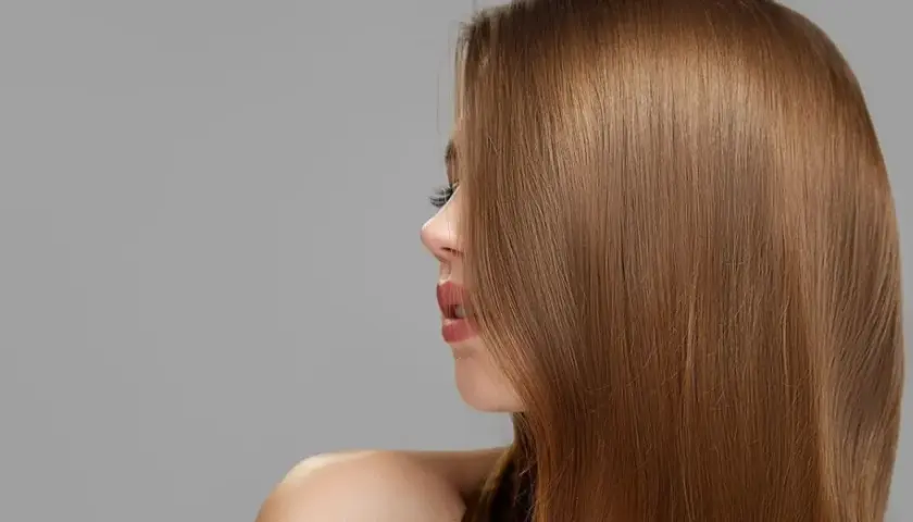 Perfil de mujer con cabello liso y sedoso de color de pelo castaño claro.