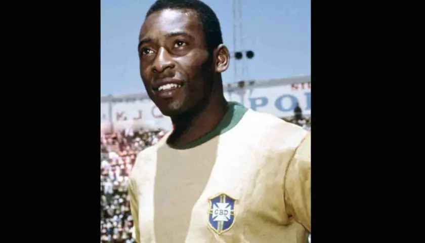 Uśmiechnięty Pelé w żółtej koszulce z herbem Brazylii. Jego niesamowite pelé statystyki mówią same za siebie.