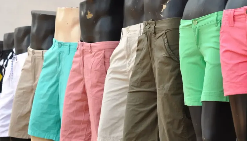 Varios maniquíes exhiben un outfit de pantalon corto hombre en colores vibrantes: rosa, verde, beige y con estampados.
