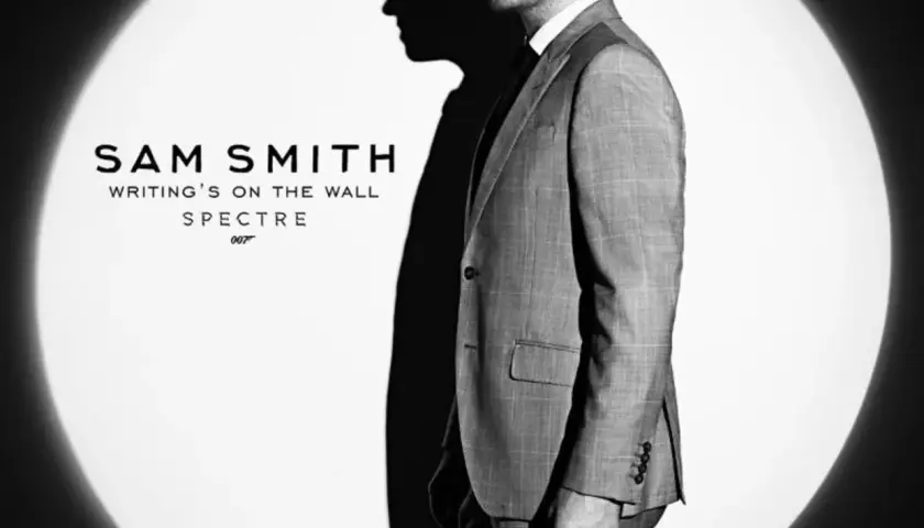 Sam Smith w garniturze, w świetle reflektora, promuje swój utwór "Writing's on the Wall" do filmu o Jamesie Bondzie, Spectre.