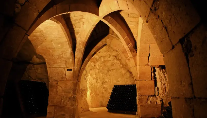 Cave voûtée de la maison Taittinger à Reims, où des milliers de bouteilles de champagne vieillissent patiemment.