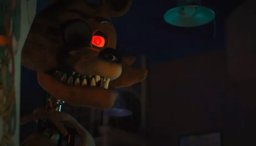 Occhio rosso minaccioso per la recensione di Five Nights at Freddy's. L'animatronic Foxy si avvicina nell'ombra.