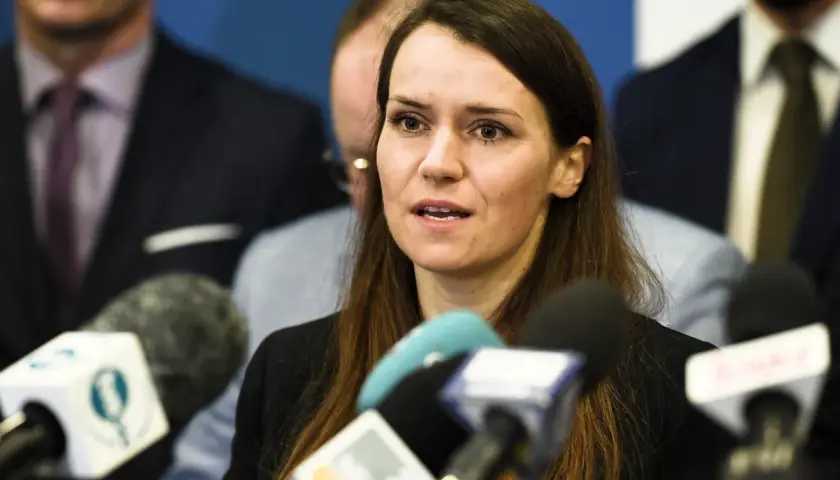 Agnieszka Pomaska przemawia do mediów. W tle widać mężczyzn, być może jej rodziców lub współpracowników.