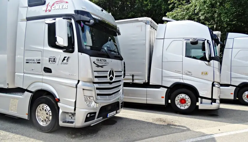 Ciężarówki z logo FIA Action for Road Safety. Szerokość samochodu osobowego jest znacznie mniejsza niż tych potężnych pojazdów.
