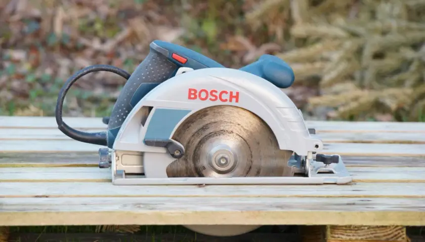 Bosch Kreissäge bereit für den Einsatz. Sie liegt auf Holzplanken, ideal zum Zerkleinern von Brennholz.