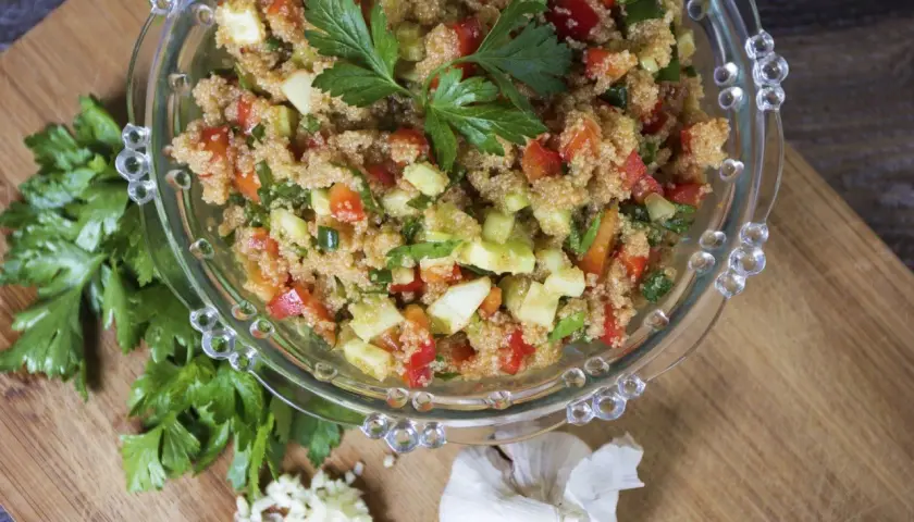 Insalata di amaranto colorata con pomodori, cetrioli e peperoni, guarnita con prezzemolo fresco.