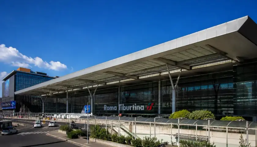 La moderna stazione di Roma Tiburtina, con la sua architettura in vetro e acciaio, accoglie viaggiatori diretti verso la metropolitana e oltre.