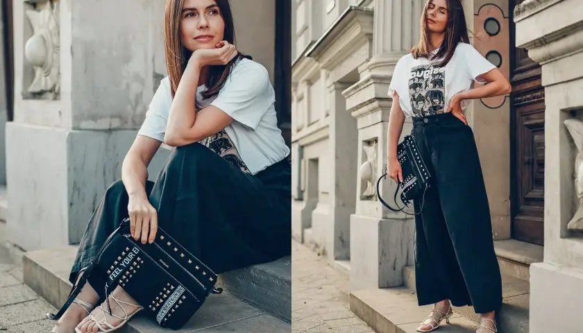 Kobieta w luźnych spodniach i t-shircie z motywem zwierzęcym, z torebką Desigual ozdobioną ćwiekami.