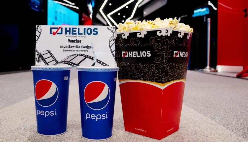 Duży popcorn Helios i dwa napoje Pepsi. Zastanawiasz się, ile kosztuje duży popcorn Helios? Ten zestaw dla dwojga z voucherem to świetna opcja.