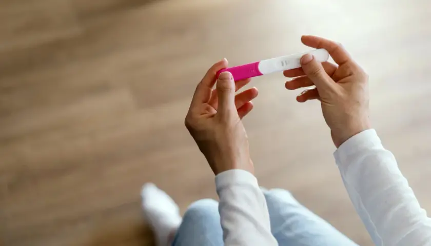 Dłonie trzymające test ciążowy. Czy za pierwszym razem można zajść w ciążę? Wynik testu jest widoczny.
