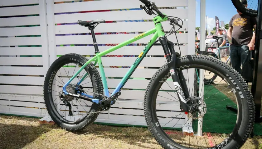 A green and blue gradient mountain bike, likely for a fat chance yo eddy review, with chunky tires and RockShox suspension.