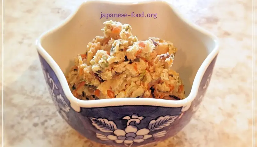 A bowl of okara salad, a healthy dish from okara recipes, filled with chopped vegetables like carrots and green beans.